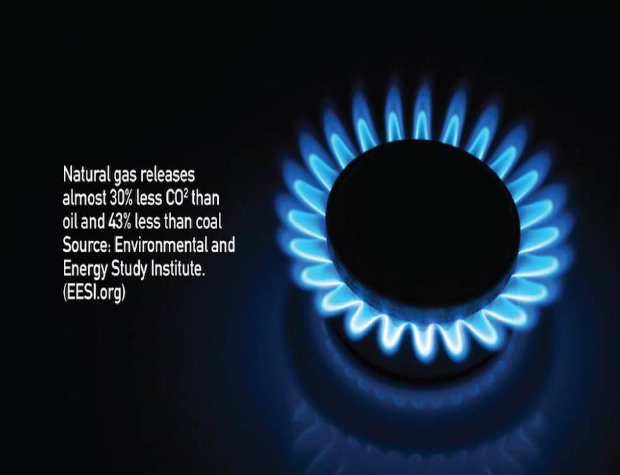 Close-up of a blue natural gas flame burning on a stovetop against a dark background.